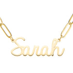 A gold-colored stainless steel chain necklace with a name 'Sarah' written in a cursive font, showing the link chain design.