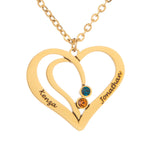A gold-plated necklace with an intertwined hearts pendant, featuring two engraved names and a small birthstone on one of the hearts.