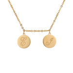 A gold-toned initial custom pendant necklace with two round discs with engraved letters.