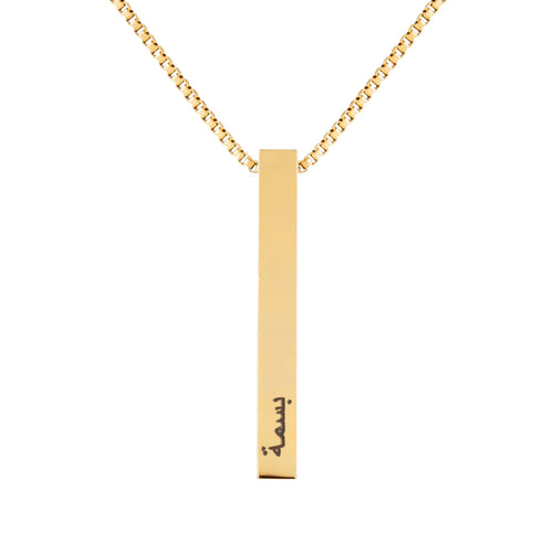 A gold-colored stainless steel bar necklace with an adjustable length and a personalized arabic text tag attached to it.