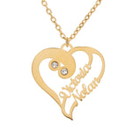 A heart-shaped pendant necklace with two names or words personalized on it, encased in delicate cursive script, with two birthstones set into the pendant, displayed on a chain.